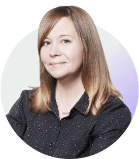 Circular profile photo of a woman with brown hair wearing a dark speckled shirt against a gradient background.